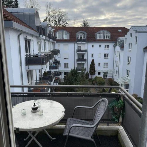 Balkon einer Unterkunft für Arbeiter in Lörrach Mitte in der Bergstraße 36A mit zwei Stühlen und einem Tisch.