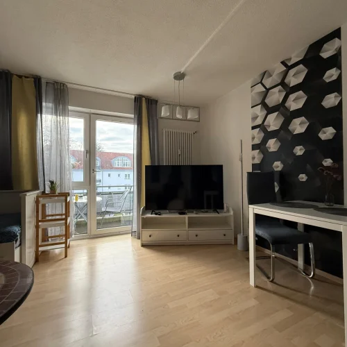 Das Wohnzimmer der Wohnung für Monteure und Handwerker in Lörrach-Mitte mit einem Esstisch und einem Fernseher.