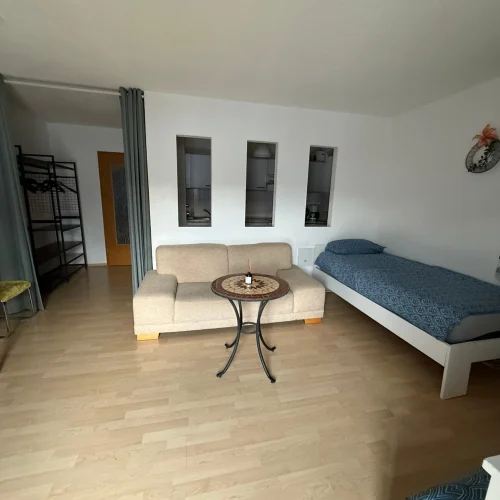 Der Wohn-Schlafbereich der Arbeiterwohnung Lörrach-Mitte in der Bergstraße mit zwei Einzelbetten und einer Couch.