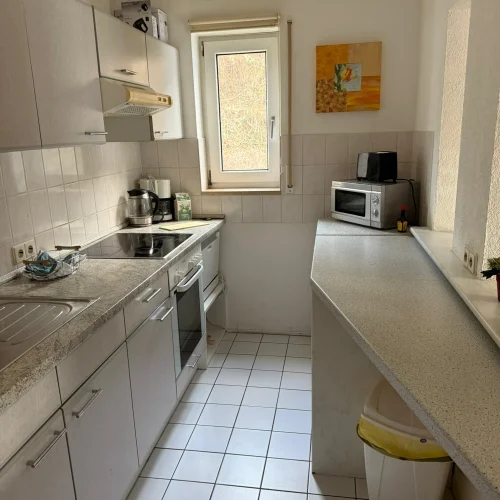 Die Küche der Arbeiterwohnung in Lörrach - voll ausgestattet mit Mikrowelle, Geschirr, Wasserkocher, Toaster und Töpfen.